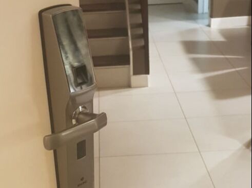 Cerradura biométrica instalada en una puerta interior, junto a una escalera